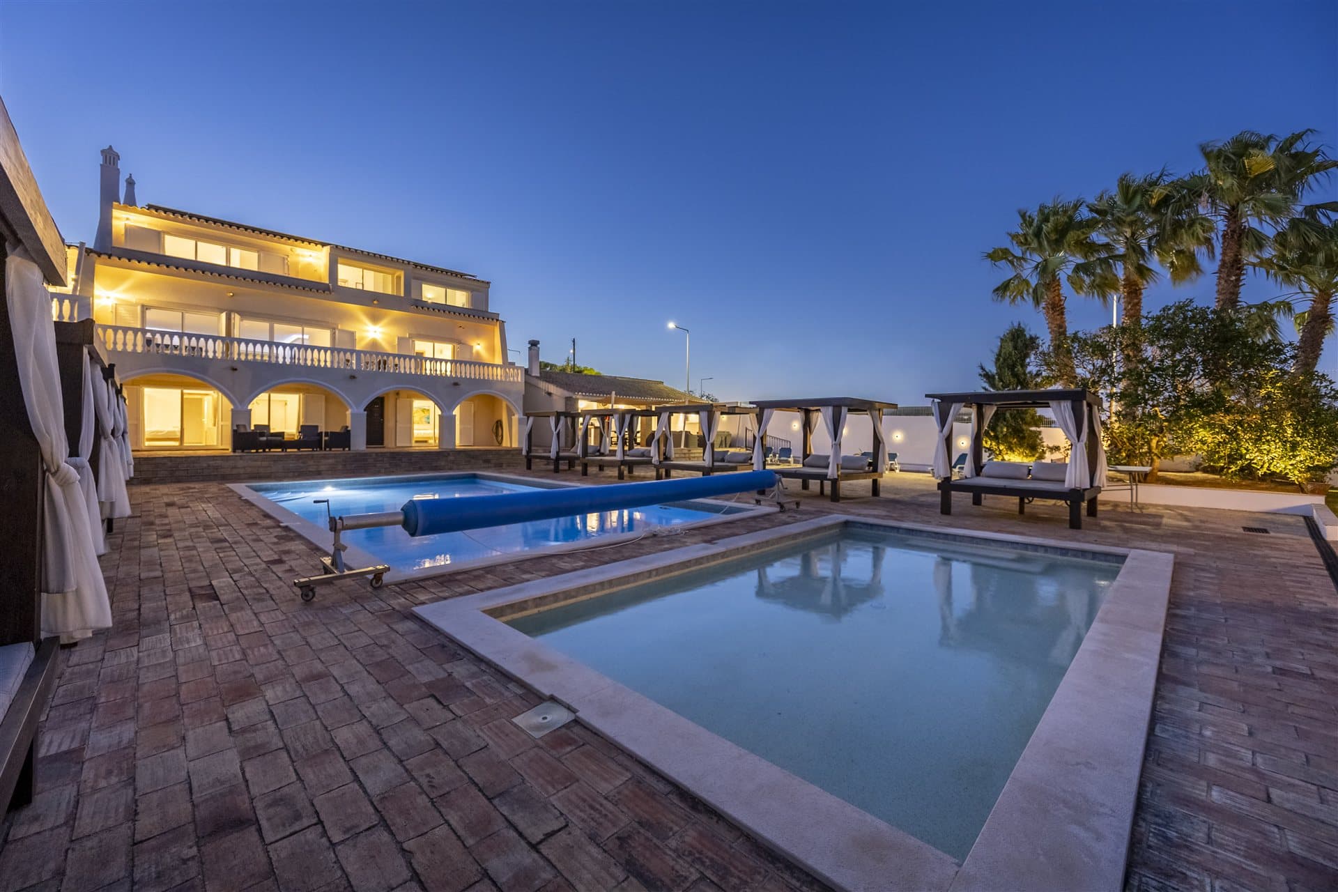 Villa Lux Luz and both pools lit up at dusk